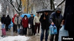 2022年11月24日，俄罗斯用导弹打击关键性民用基础设施之后，乌克兰基辅居民排队等待用瓶子接清洁饮用水。
