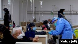 上海一家医院的医生正在帮助一名病人打点滴。（2023年1月5日）