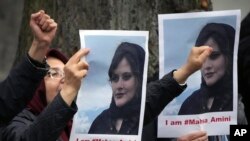 流亡伊朗人举着在伊朗警察局死亡的女子阿米尼的照片在伊朗驻柏林大使馆外抗议。（2022年9月20日）
