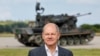 Канцлер Німеччини Олаф Шольц стоїть перед німецькою самохідною зенітною установкою Flakpanzer Gepard під час відвідування програми навчання українських солдатів на зенітному танку Gepard у Путлосі біля Ольденбурга, Німеччина, 25 серпня 2022 року.