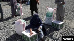 一名阿富汗妇女在首都喀布尔领取沙特阿拉伯提供的人道援助（2022年4月25日）