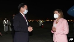 美国国会众议院议长佩洛西2022年8月2日晚抵达台北松山机场后与迎接她的台湾外长吴钊燮交谈。
