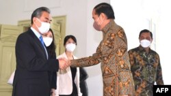 2022年7月11日印度尼西亚总统佐科·维多多(右)在雅加达独立宫与中国外交部长王毅(左)握手