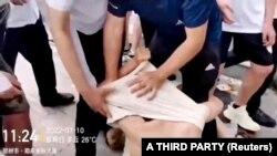 中国河南村镇银行储户在郑州抗议期间，便衣警察拖拽抗议者时把他的衣物拉起套住头部。（2022年7月10日）