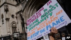 Protesters stand outside the High Court where the ruling on Rwanda deportation flights is taking place, in London on June 13, 2022.