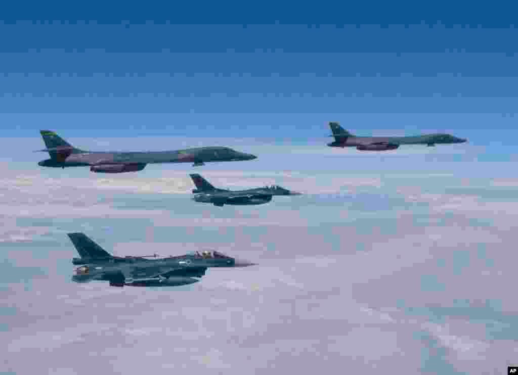 日本航空自卫队发布的这张照片显示，从关岛的安德森空军基地起飞的美国超音速B-1B型轰炸机在日本南部的九州岛上空飞行。日本自卫队的F-2战斗机伴随。（2017年7月30日）
