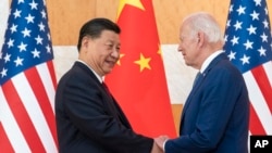 资料照片：2022年11月14日，美国总统拜登和中国国家主席习近平在印度尼西亚巴厘岛举行的G20峰会期间举行会议前握手。（美联社照片）
