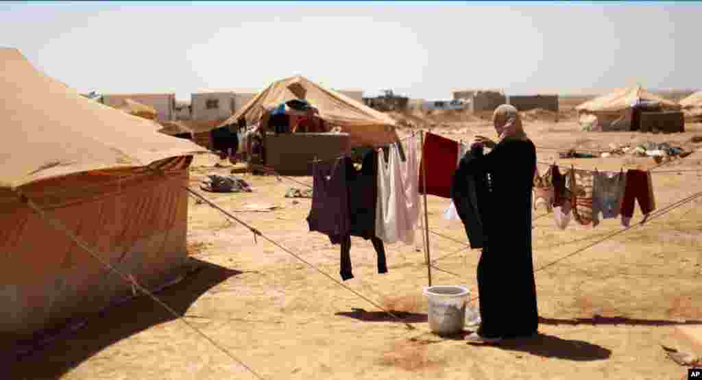 A Syrian refugee hangs clothes to dry at Zaatari Refugee Camp, in Mafraq, Jordan, September 2, 2012.