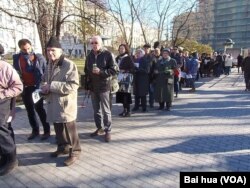 人们手持蜡烛和鲜花，排起长队等待宣读遇难者的姓名 (美国之音白桦拍摄)