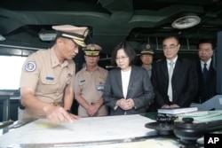 台湾总统蔡英文(中左)登上台湾海军军舰，在军舰出发前往南中国海巡逻前，视察海事表。