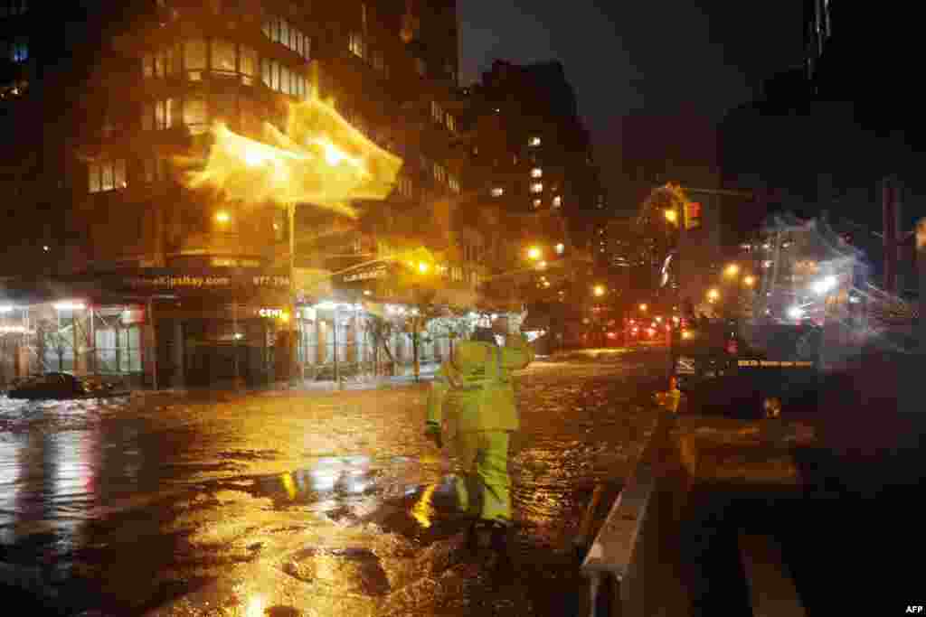 2012年10月29日,爱迪生联合电力公司的一名工人冒雨走过纽约市33街和第一大道街角,前方是曼哈顿的朗格尼医学中心(Langone Medical Center)。(Michael Heiman/Getty Images/AFP)