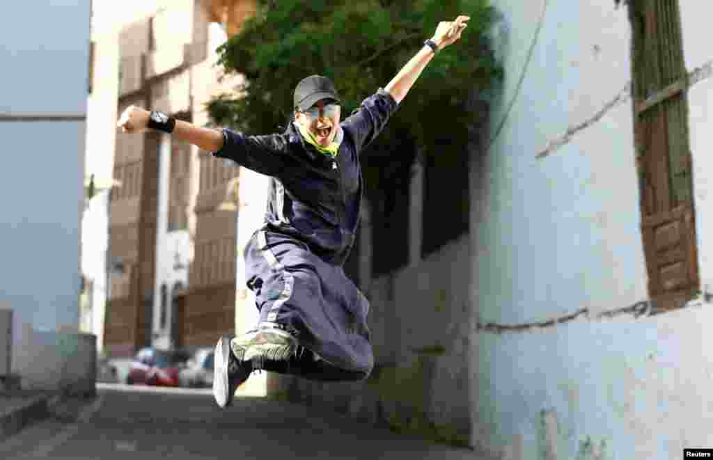 Saudi woman Nouf Khayat, a Zumba instructor, jumps during a running event marking International Women's Day in Old Jeddah, Saudi Arabia.