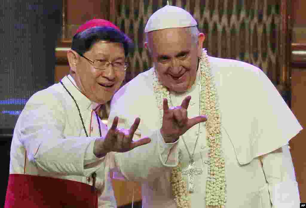 Hồng y Philippines Luis Antonio Tagle hướng dẫn Đức Giáo Hoàng Phanxicô làm dấu hiệu "Tôi yêu bạn" tại Manila, ngày 16/1/2015.