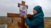 Ірина Орфіняк біля могили її онучки Вероніки, яка загинула разом із батьком під час обстрілів Росією Маріуполя, 9 листопада 2022. REUTERS/Alexander Ermochenko