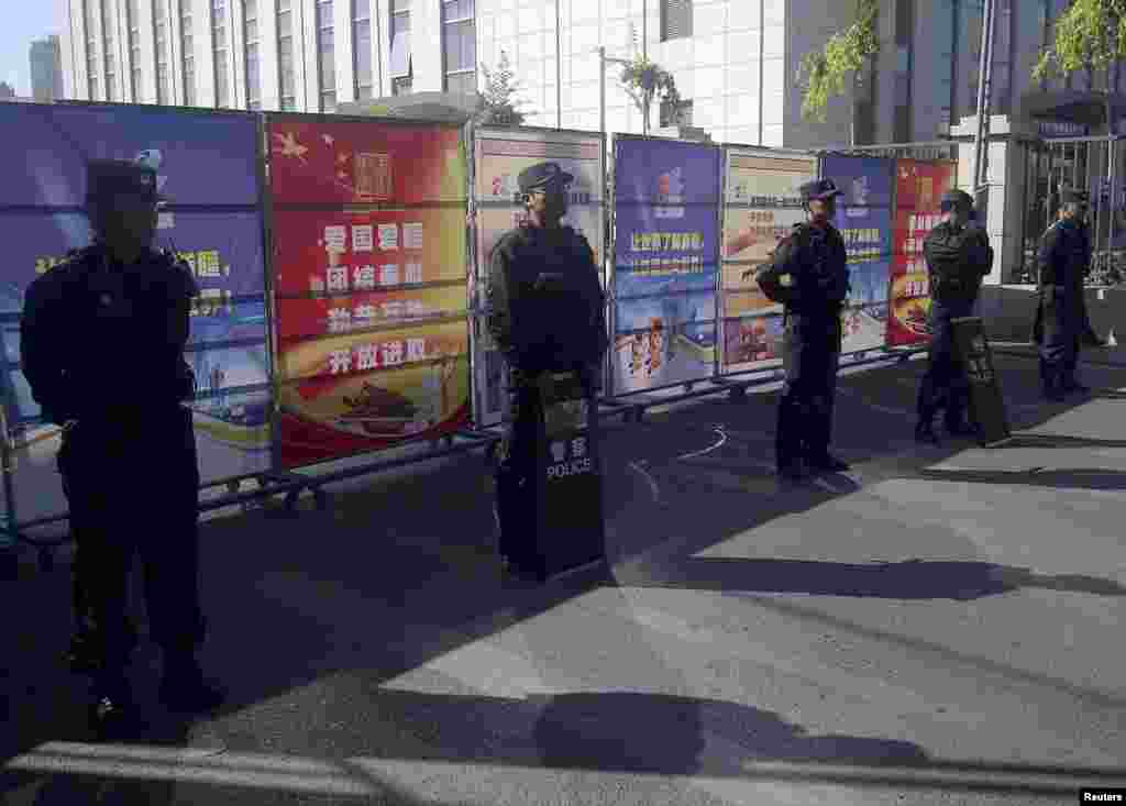 携带防暴装备的警察在新疆乌鲁木齐中级法院附近的检查站站岗,2014年9月17日这家法院审理伊力哈木的案子。