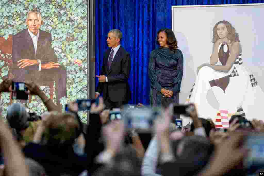 Former President Barack Obama and former first lady Michelle Obama stand on stage together as their official portraits are unveiled at a ceremony at the Smithsonian's National Portrait Gallery in Washington, D.C.