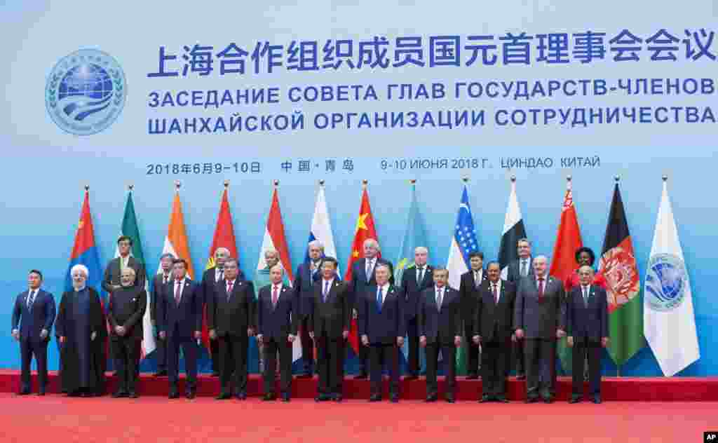 在中国山东省举行的上海合作组织首脑会议上,中国国家主席习近平,俄罗斯总统普京与其他国家领导人合影(2018年6月10日)。多国领导人访华,中国官媒营造“万邦来朝”的景象。青岛峰会与会国增加了新入会的印度和巴基斯坦,以及具有观察员地位的伊朗、蒙古国、阿富汗和白俄罗斯,还有对话伙伴国土耳其、尼泊尔、柬埔寨、阿塞拜疆、亚美尼亚和斯里兰卡。专家认为,上合组织未来有进一步扩大的趋势。此外,上合组织成员国已经多次进行了反恐军事演习。