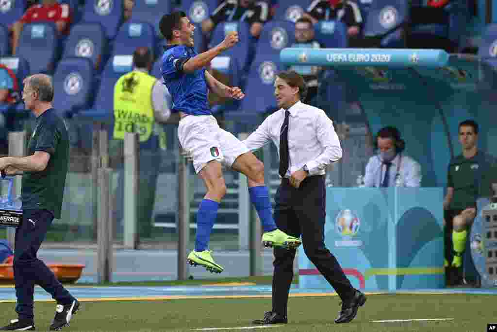 Italy's Matteo Pessina celebrates with coach Roberto Mancini after scoring his side's opening goal during the Euro 2020 soccer championship group A match between Italy and Wales, at the Rome Olympic stadium, Italy.