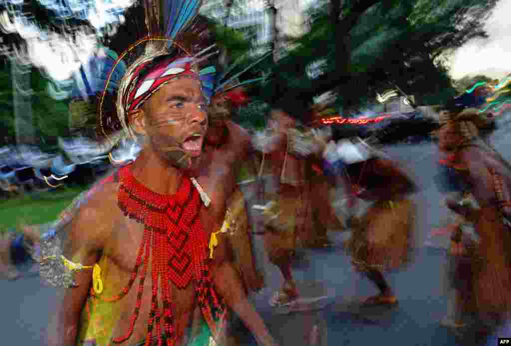 Brazilian indigenous men perform a ritual dance during a protest against the government's decision not to recognize the land demarcation of indigenous people living in Raposa Serra do Sol, Roraima State, in Brasilia.