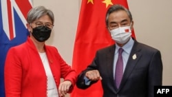 资料照：在印尼度假胜地巴厘岛努沙杜瓦举行的二十国集团外长会议期间，澳大利亚外交部长黄英贤(左)与中国外交部长王毅碰肘互致问候。（2022年7月8日）
