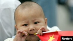 资料照：一个中国幼童手拿一面中国国旗。