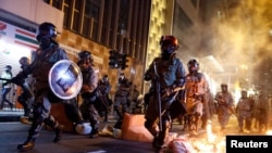 资料照：香港防暴警察走过一个燃烧的路障去驱散抗议民众。（2019年11月2日）