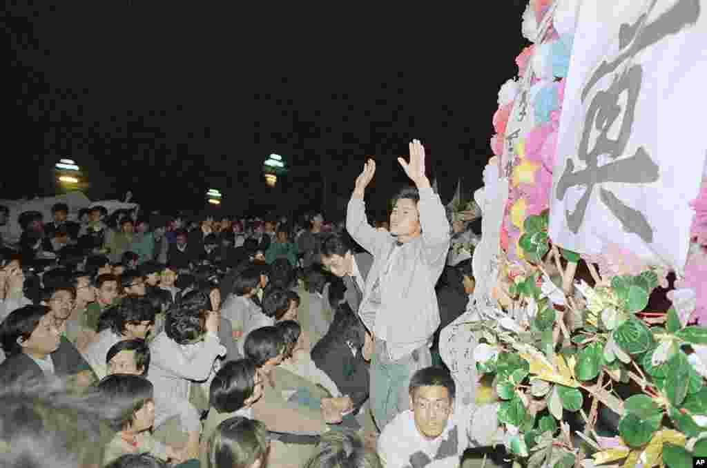 天安门广场上一名学生领袖试图让一群北大学生镇定下来，结果却是白费力。学生们4月18日在天安门广场示威一天后，第二天曾汇聚在中南海门前，试图冲击大门，但被警方阻止（1989年4月19日）
