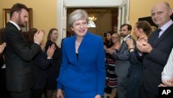 英国首相特蕾莎·梅2017年6月9日在寻求女王批准成立新政府之后返回唐宁街首相官邸时，受到工作人员的欢迎。