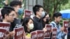 台港青年学生团体5月28日在台北的香港经贸办事处前举牌呼吁：“恶法压境齐心共进”、“防疫当前也要上学”。（美国之音李玟仪摄）