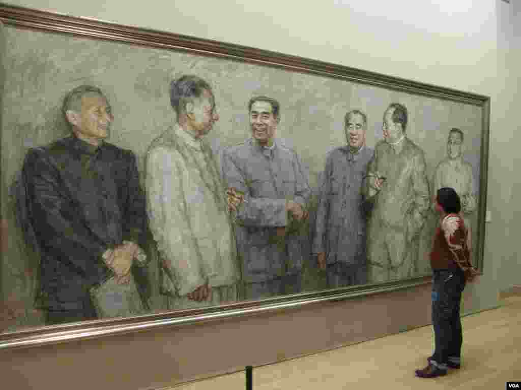 中国画展中有人观看中共文革前政治局常委的肖像画,右起:邓小平、毛泽东、朱德、 周恩来、刘少奇、陈云。常委中的林彪不在画上(美国之音张楠拍摄)