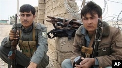 Cảnh sát Afghanistan canh gác trước cổng chính của một cơ sở quân sự ở Lashkar Gah, tỉnh Helmand, miền nam Afghanistan