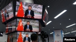 资料照片：上海举行的中国国际进出口展销会媒体中心的多面电视屏幕正在播放中国领导人习近平的讲话。（2021年11月4日）