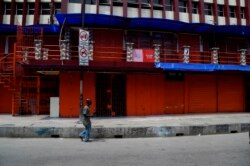 A man walk past a closed shop in compliance with a seven-day partial shutdown by the state government to combat the spread of the COVID-19 coronavirus in Lagos, on March 27, 2020.