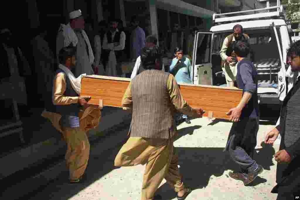 Afghans carry a coffin of the body of a woman who was killed by gunmen in the city of Jalalabad, east of Kabul. Attackers gunned down three women working to administer the anti-polio vaccine in eastern Afghanistan, officials said.