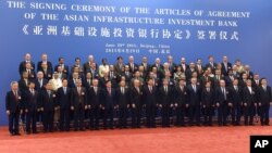 中国国家主席习近平(右九)在北京人民大会堂与参加亚洲基础设施投资银行创始成员国签字仪式的各国代表合影。（2015年6月29日）