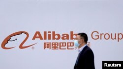 2020年11月23日，在浙江乌镇举行世界互联网大会期间，一个路人从阿里巴巴公司图标前走过。
