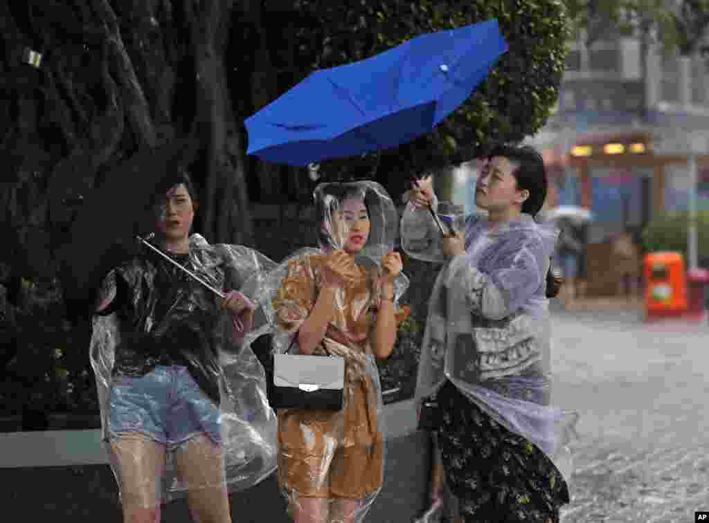 2017年8月27日,在香港维多利亚港附近,人们在热带风暴的强风袭击下。