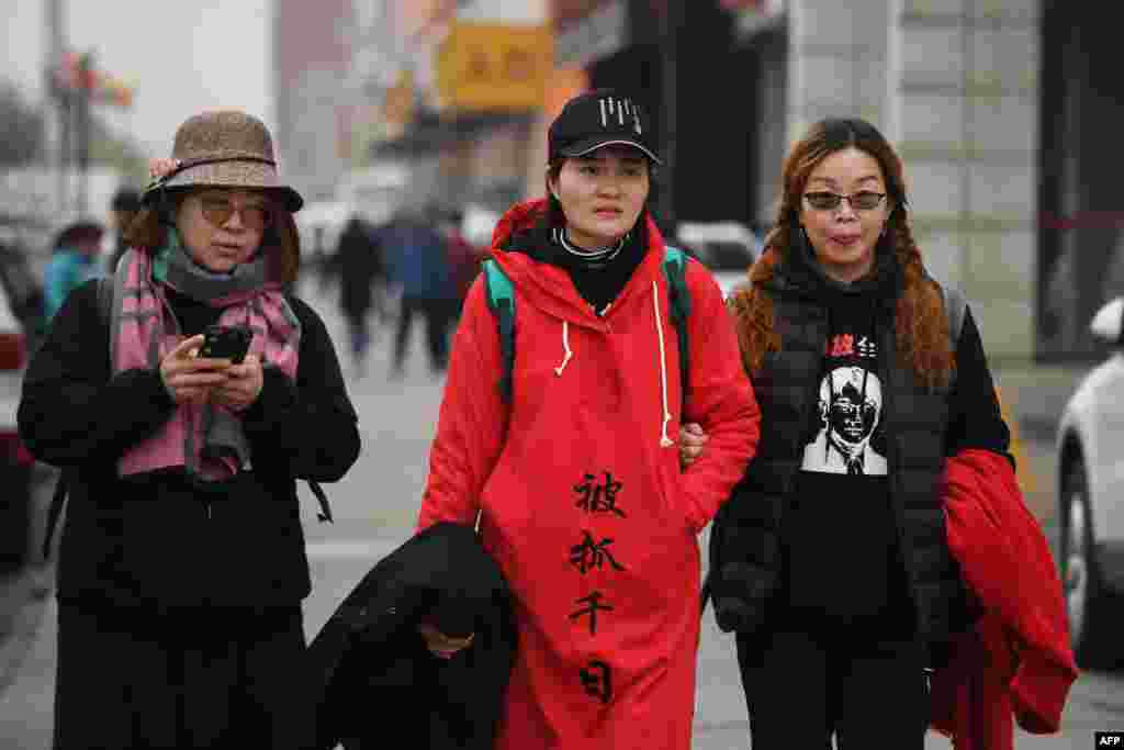 被拘留维权律师王全璋的妻子李文足(中),维权律师李和平的妻子王峭岭(左)和人权人士翟岩民的妻子刘二敏2018年4月5日在北京郊区游行。后来李文足从北京游行到天津,寻找丈夫,控告办案机关。李文足在天津被执法人员带走,随后获释,被软禁在北京的家中。