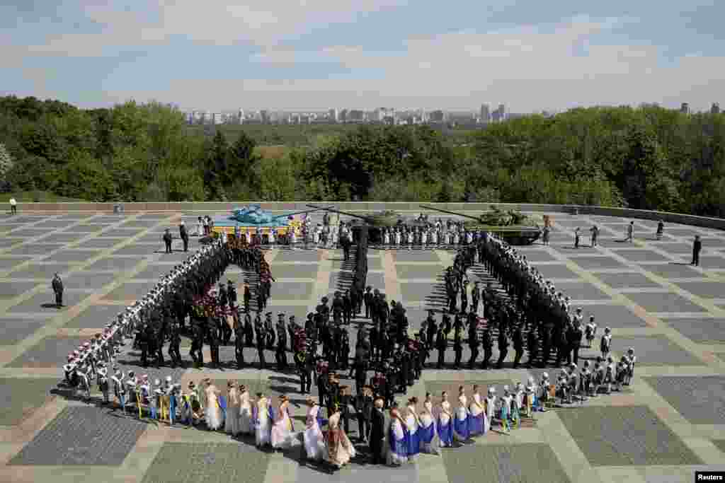 Participants gather to form the state coat of arms of Ukraine during a ceremony, dedicated to the 73rd anniversary of the victory over Nazi Germany in World War Two, at the compound of the World War Two museum in Kiev, Ukraine.