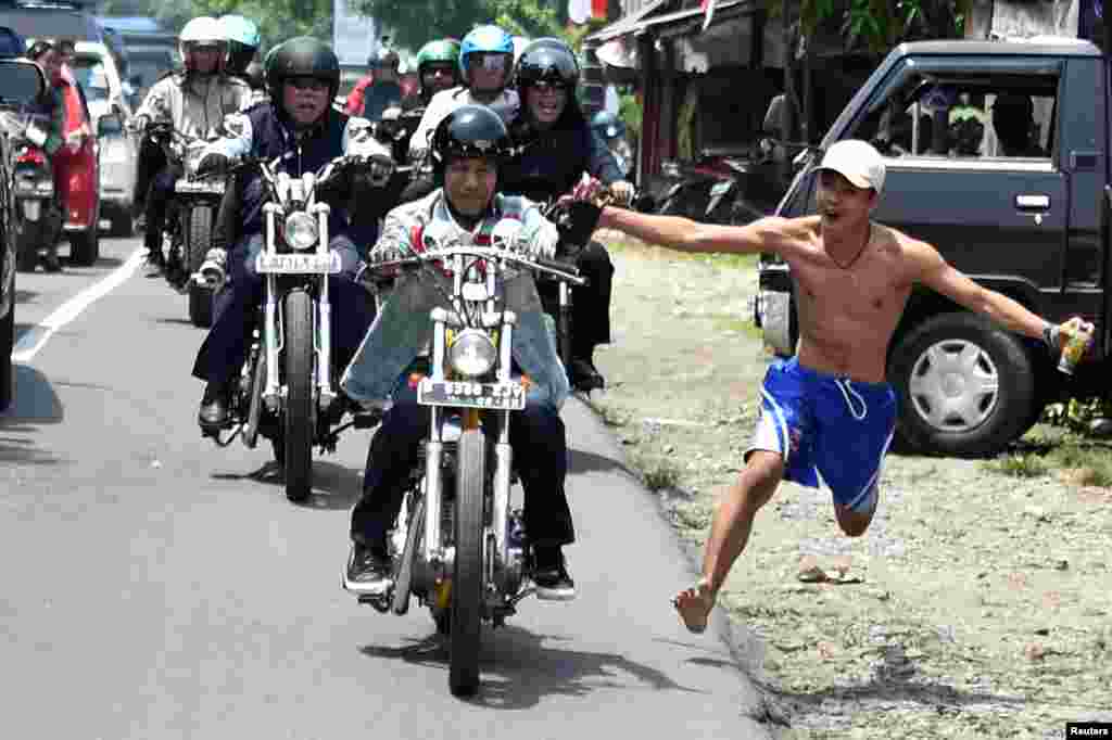 Indonesian President Joko Widodo rides Royal Enfield motorbike during his visit at Pelabuhan Ratu beach in Sukabumi.