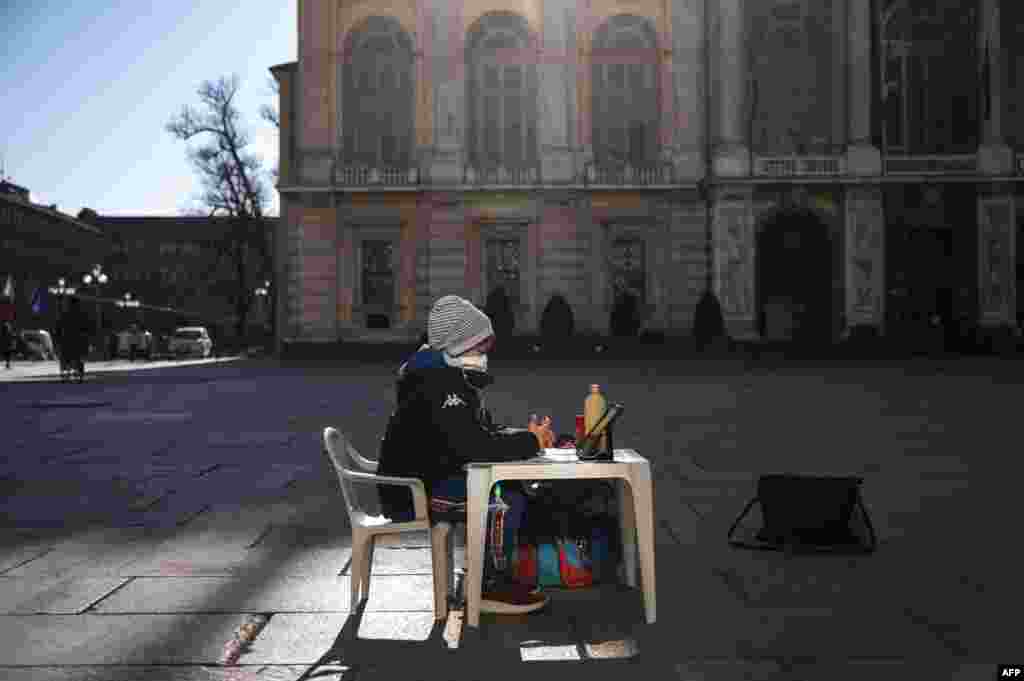 A pupil sits at a desk on Piazza Castello during a protest against the closure of schools from the seventh grade up, following new government restrictions over the COVID-19 pandemic, in Turin, Italy.