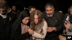 Mwanaharakati wa Palestina Ahed Tamimi, kati, akisaidiwa na mama yake baada ya kuachiliwa kutoka katika jela ya Israel, huko Ramallah, mji ulioko Ukingo wa Magharibi mapema Alhamisi, Nov. 30, 2023. (AP Photo/Nasser Nasser)