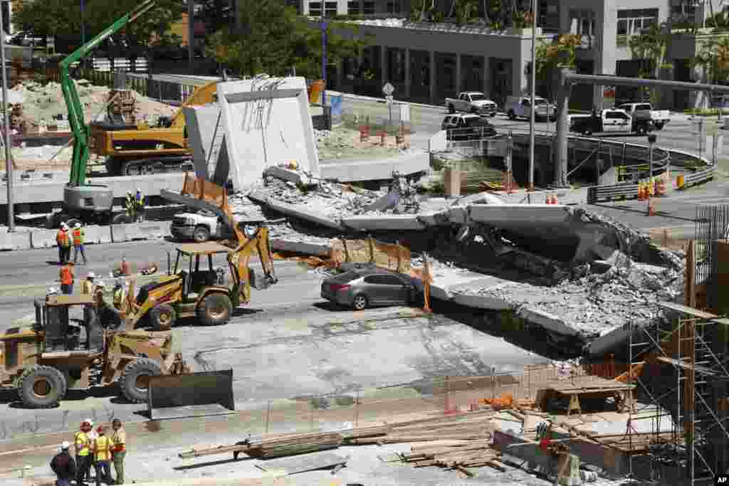 Crushed cars are shown under a section of a collapsed pedestrian bridge near Florida International University in the Miami area. The new pedestrian bridge that was under construction collapsed onto a busy Miami highway Thursday afternoon, crushing vehicle