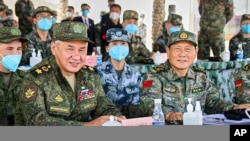 资料照：中国国防部长魏凤和（右）与俄罗斯国防部长邵伊古（左）在中国宁夏视察中俄联合军演。（2021年8月13日）