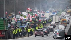 Польські фермери блокують тракторами головну дорогу під час протесту в Ломянках, поблизу Варшави, 6 березня 2024 р., вимагаючи закрити польсько-український кордон для імпорту харчових продуктів з України до Європейського Союзу. (Фото: AP Photo/Czarek Sokolowski)