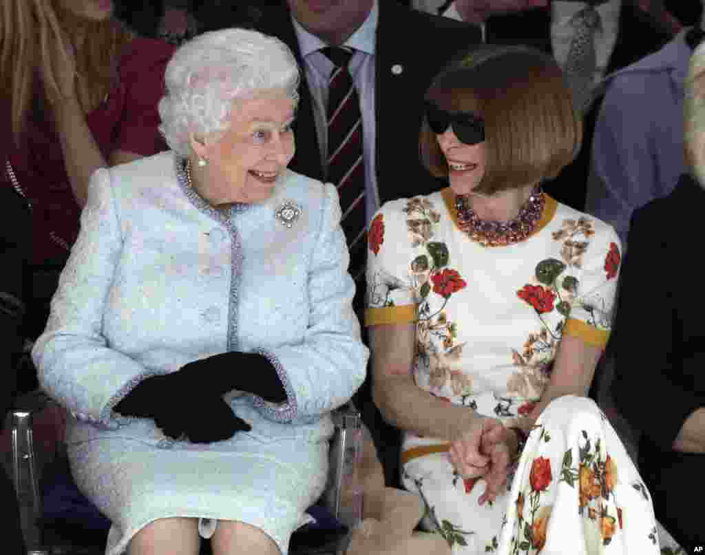 Britain's Queen Elizabeth sits next to fashion editor Anna Wintour as they view Richard Quinn's runway show before presenting him with the inaugural Queen Elizabeth II Award for British Design, during her visit to London Fashion Week's BFC Show Space in central London.
