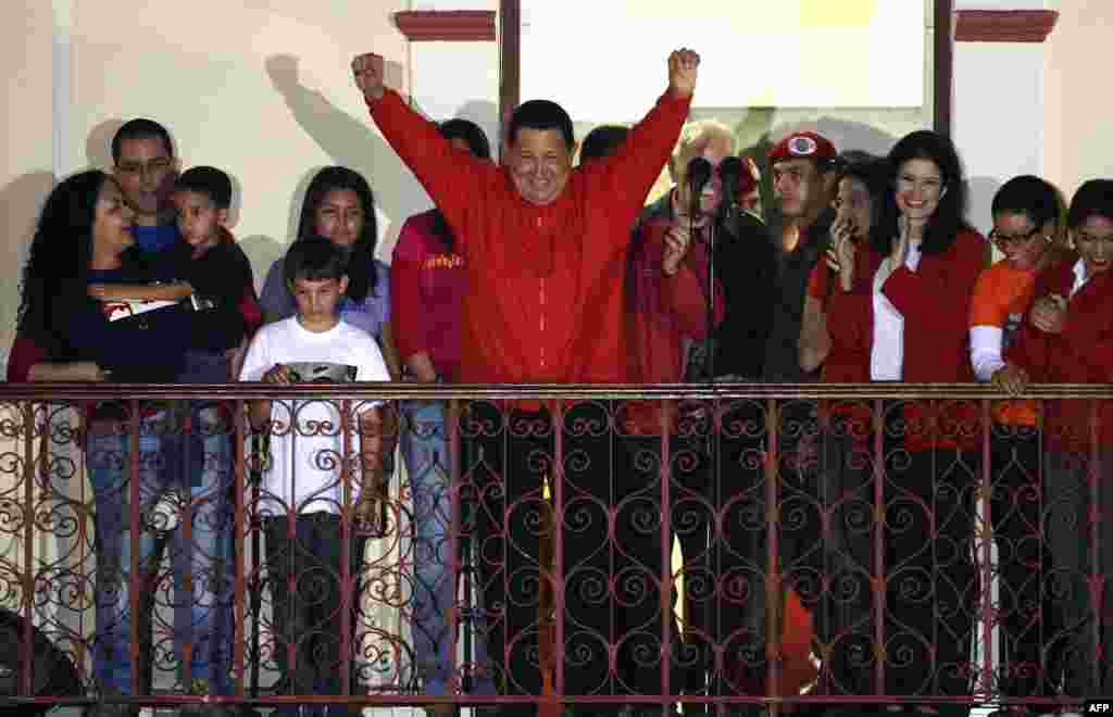 Ông Hugo Chavez làm dấu hiệu chiến thắng khi phát biểu trước các ủng hộ viên sau khi có tin ông tái đắc cử tổng thống ở Caracas.