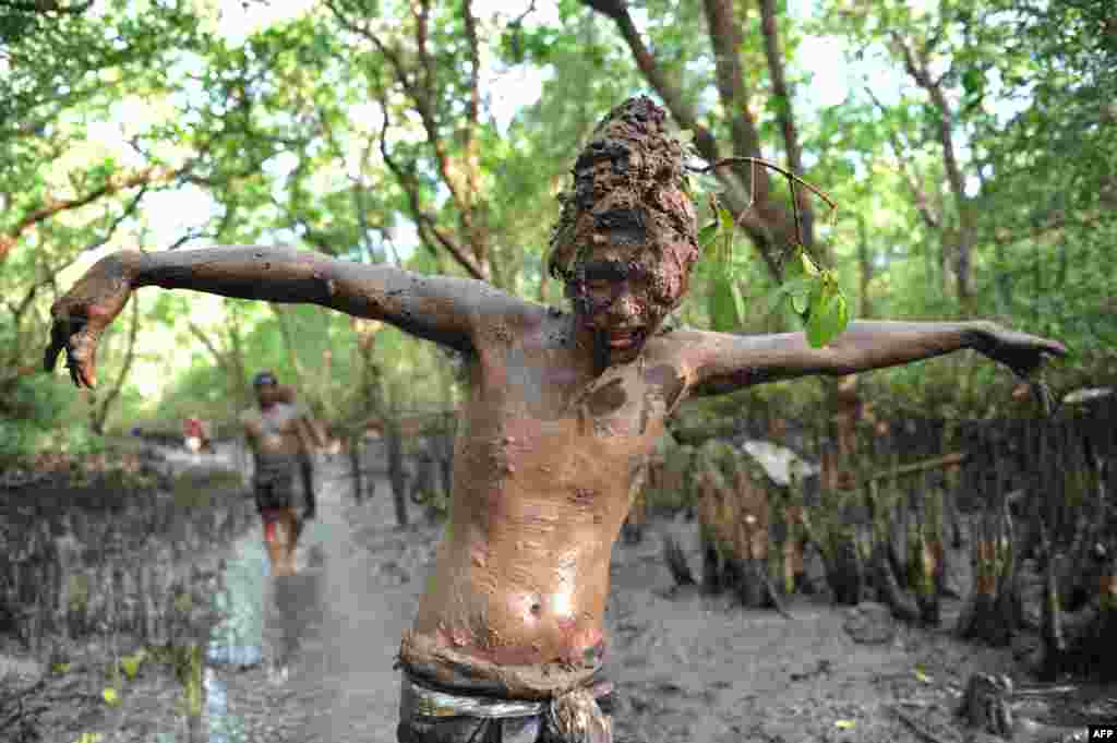 A Balinese boy puts mud on his body during a traditional mud baths known as Mebuug-buugan, in Kedonganan village, near Denpasar on Indonesia's resort island of Bali, Indonesia.