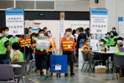 香港选举人员在为选举委员会举行投票后在点票中心交付投票箱。 （2021年9月19日）