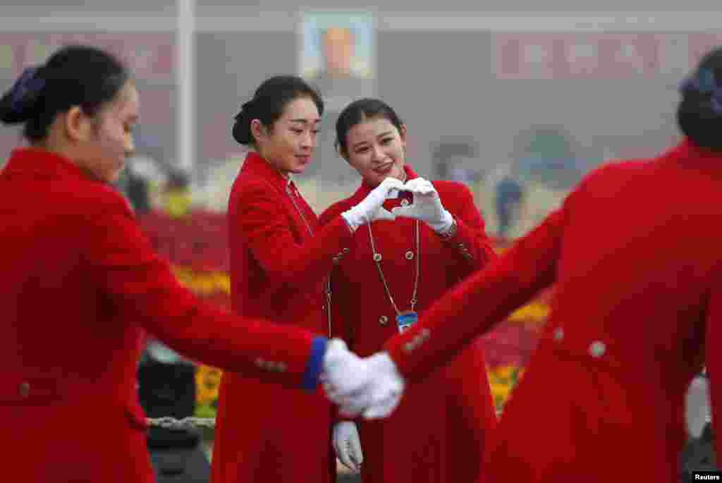 中国共产党第十九次全国代表大会在北京人民大会堂开幕之际,接待员在天安门广场拍照(2017年10月18日)。香港苹果日报说,中共十九大美女接待员成为场外亮点。